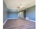 Large, naturally lit room with a ceiling fan and wood laminate flooring at 6370 Conniewood Sq, New Port Richey, FL 34653