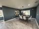 Elegant dining room with modern light fixture, ample seating, and serene window views at 6370 Conniewood Sq, New Port Richey, FL 34653