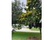 Charming home with a circular driveway, lush green lawn, and beautiful, mature trees creating a serene setting at 6370 Conniewood Sq, New Port Richey, FL 34653
