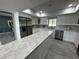 Bright kitchen featuring white cabinetry, stainless steel appliances, and a large marble-topped island at 6370 Conniewood Sq, New Port Richey, FL 34653