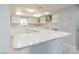 Bright kitchen featuring white cabinets, marble countertops, and a skylight at 6370 Conniewood Sq, New Port Richey, FL 34653