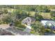 An aerial view features the home and surrounding area with mature trees and green lawns at 5277 Epping Ln, Zephyrhills, FL 33541