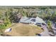 Aerial view featuring a clubhouse next to a golf course, trees, and waterfront at 5277 Epping Ln, Zephyrhills, FL 33541