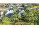 An overhead perspective of a house with mature trees and a screened lanai at 5277 Epping Ln, Zephyrhills, FL 33541