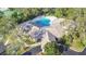 An aerial view shows a community pool area with abundant seating, manicured landscaping and ample parking at 5277 Epping Ln, Zephyrhills, FL 33541