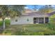 The back of a light-colored home with a screened-in porch and well-maintained lawn at 5277 Epping Ln, Zephyrhills, FL 33541