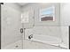 Modern bathroom featuring marble tile, a soaking tub, and a glass-enclosed shower at 5277 Epping Ln, Zephyrhills, FL 33541