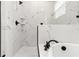 A bathroom with a white marble walk-in shower, soaking tub, and black fixtures at 5277 Epping Ln, Zephyrhills, FL 33541