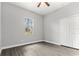 An empty bedroom with wood-look floors, a closet, and a window at 5277 Epping Ln, Zephyrhills, FL 33541
