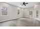 Bedroom with ceiling fan, light gray walls, hardwood floors, and large windows at 5277 Epping Ln, Zephyrhills, FL 33541