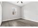 An empty bedroom with wood-look floors and a large window at 5277 Epping Ln, Zephyrhills, FL 33541