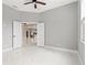 Bedroom with white marble floors, ceiling fan, and doorway view to living area at 5277 Epping Ln, Zephyrhills, FL 33541