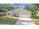 Charming single-story home with a well-manicured lawn and a two-car garage at 5277 Epping Ln, Zephyrhills, FL 33541