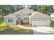 Inviting home with a well-maintained lawn, mature trees, and an attached two-car garage at 5277 Epping Ln, Zephyrhills, FL 33541