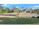 Expansive light-colored home featuring lush green lawns and mature trees under a clear blue sky at 5277 Epping Ln, Zephyrhills, FL 33541