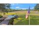 View of a lush green golf course with the American flag proudly displayed on a sunny day at 5277 Epping Ln, Zephyrhills, FL 33541