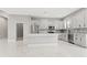 Large kitchen with a gray center island, stainless appliances, white cabinets and marble floors at 5277 Epping Ln, Zephyrhills, FL 33541