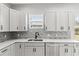 Close up of kitchen featuring stainless steel appliances and elegant white cabinetry with stone backsplash at 5277 Epping Ln, Zephyrhills, FL 33541