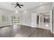 A spacious living room with high ceilings, wood-look floors, access to the patio, and an open doorway to the kitchen at 5277 Epping Ln, Zephyrhills, FL 33541