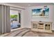 Living area showcasing a large TV and access to a private balcony at 18400 Gulf Blvd # 1206, Indian Shores, FL 33785