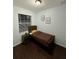 Cozy bedroom featuring a twin-size bed, nightstand, and dark wood floors at 8169 Olsen St, Port Charlotte, FL 33981