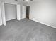 Well-lit bedroom featuring gray carpet and double doors to closet at 6844 Northlake Dr, Zephyrhills, FL 33542