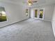 Main bedroom with plush carpeting, ceiling fan and French doors at 6844 Northlake Dr, Zephyrhills, FL 33542