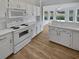 White kitchen features a view to the sunroom and backyard at 6844 Northlake Dr, Zephyrhills, FL 33542