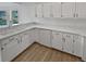 White kitchen with double sink, dishwasher, and light wood flooring at 6844 Northlake Dr, Zephyrhills, FL 33542