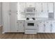 White kitchen with stove, microwave, and ample cabinetry at 6844 Northlake Dr, Zephyrhills, FL 33542