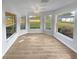 Sunroom with wood-look floors and multiple windows at 6844 Northlake Dr, Zephyrhills, FL 33542