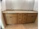 Bathroom featuring double sinks with granite countertops and wood-look cabinetry at 12263 Cartouche Ave, Punta Gorda, FL 33955