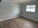 Comfortable bedroom with wood-look flooring, a window for natural light, and neutral decor at 12263 Cartouche Ave, Punta Gorda, FL 33955