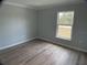 Bedroom with luxury vinyl plank flooring, and natural light from a large window at 12263 Cartouche Ave, Punta Gorda, FL 33955