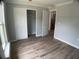Bedroom featuring luxury vinyl plank flooring, closet, and view to kitchen at 12263 Cartouche Ave, Punta Gorda, FL 33955