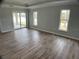 Bright and airy living room features sliding glass doors to the patio and wood-look flooring at 12263 Cartouche Ave, Punta Gorda, FL 33955