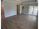Open-concept living room with wood-look flooring and views of the kitchen and outdoor patio at 12263 Cartouche Ave, Punta Gorda, FL 33955