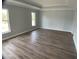 Spacious main bedroom with wood-look flooring, tray ceiling, and natural light from the windows at 12263 Cartouche Ave, Punta Gorda, FL 33955