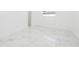 Bright bedroom features all-white walls, white trim and baseboards, and large format marble tile floor at 4367 Albacore Cir, Port Charlotte, FL 33948