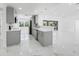Open concept kitchen with grey cabinets, quartz counters, and stainless appliances overlooks living spaces at 4367 Albacore Cir, Port Charlotte, FL 33948