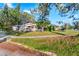 Side view of a house with a red door and green lawn at 2695 S East Ave, Sarasota, FL 34239