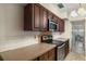 Kitchen features dark wood cabinets, an electric stovetop, and a built-in microwave at 2695 S East Ave, Sarasota, FL 34239