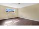 Empty bedroom with hardwood-style flooring and a large window at 10751 Carloway Hills Dr, Wimauma, FL 33598