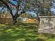 Backyard view showing a large tree, fence, and detached building at 10009 Connecticut St, Gibsonton, FL 33534