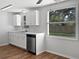 Kitchen with white cabinets, stainless steel dishwasher and view to backyard at 10009 Connecticut St, Gibsonton, FL 33534