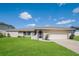 Single-story home with a well-maintained lawn and attached garage at 23104 Newcun Ave, Punta Gorda, FL 33980
