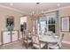 Elegant dining room with a large table, chandelier, and hardwood floors at 7044 Foxboro Way, Nokomis, FL 34275