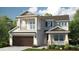 Two-story home with balcony, brown garage door, and landscaping at 7044 Foxboro Way, Nokomis, FL 34275