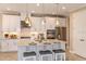 Modern kitchen with white cabinets, granite island, and stainless appliances at 7044 Foxboro Way, Nokomis, FL 34275