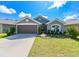 Gray house with brown garage door, landscaping, and driveway at 14308 Edinburgh Moor Dr, Wimauma, FL 33598